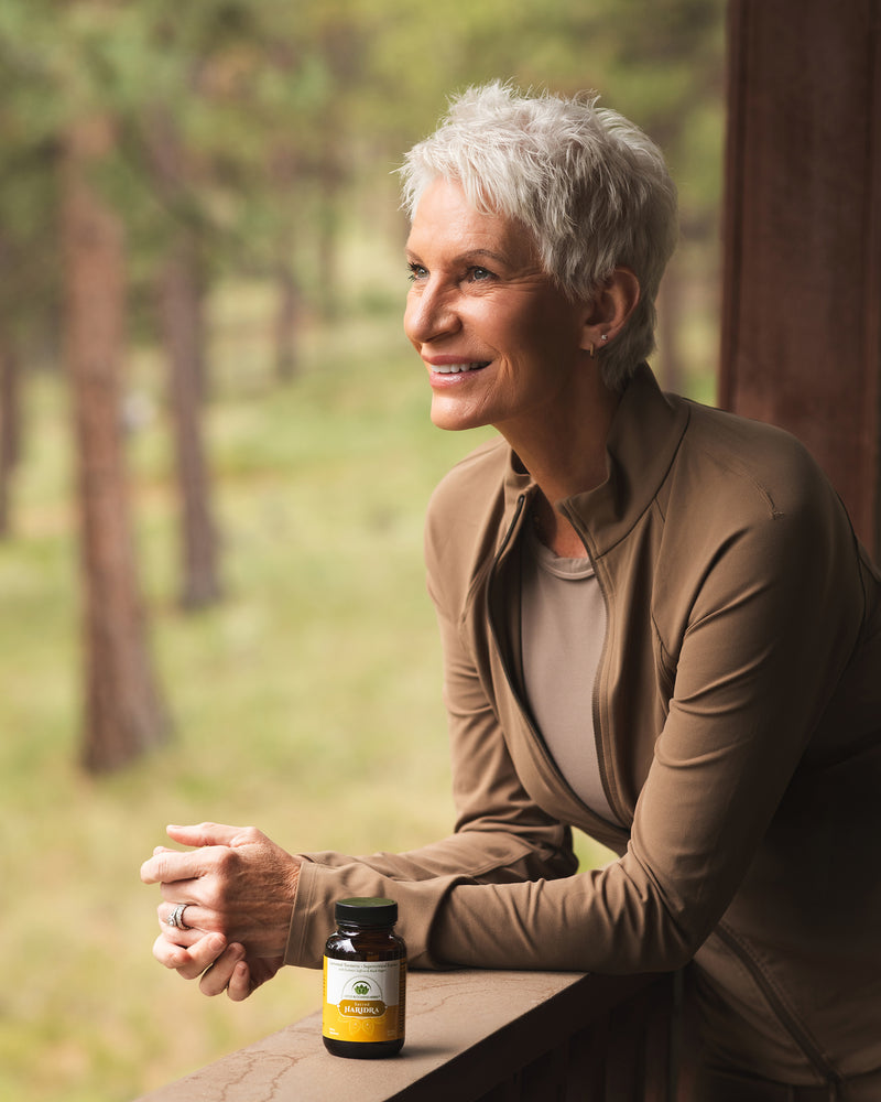 Woman outdoors with a bottle of a turmeric supplement 