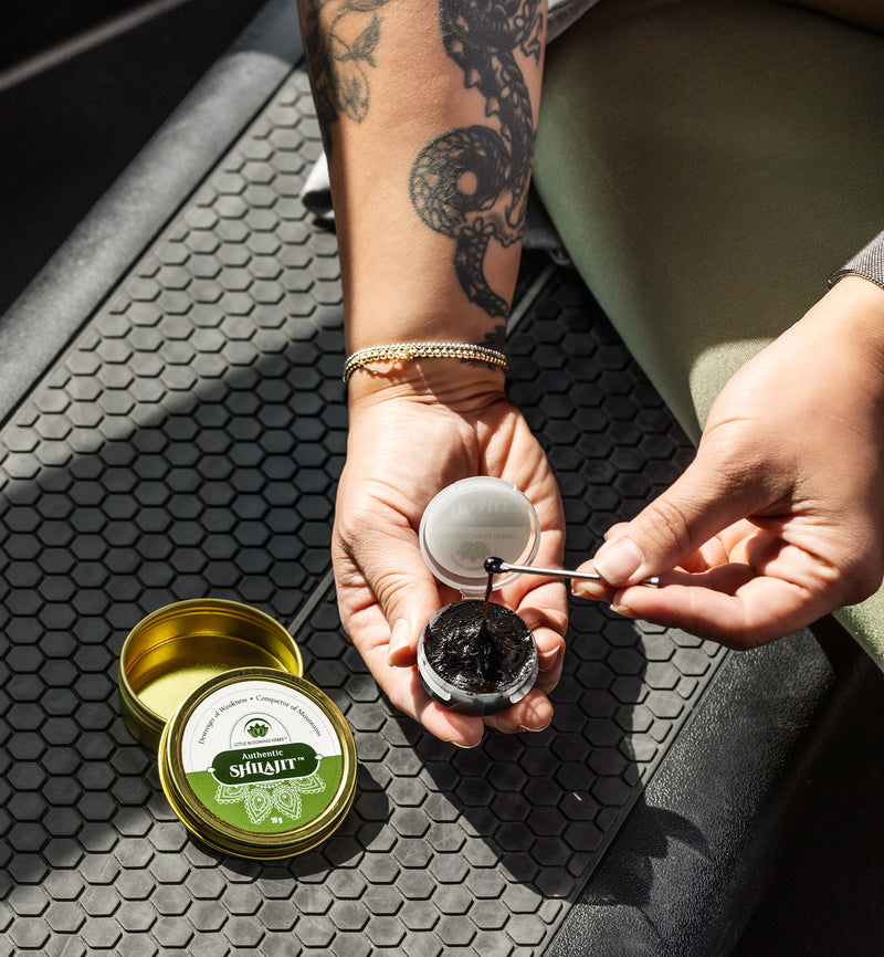 Person using a small container of shilajit in a gym.
